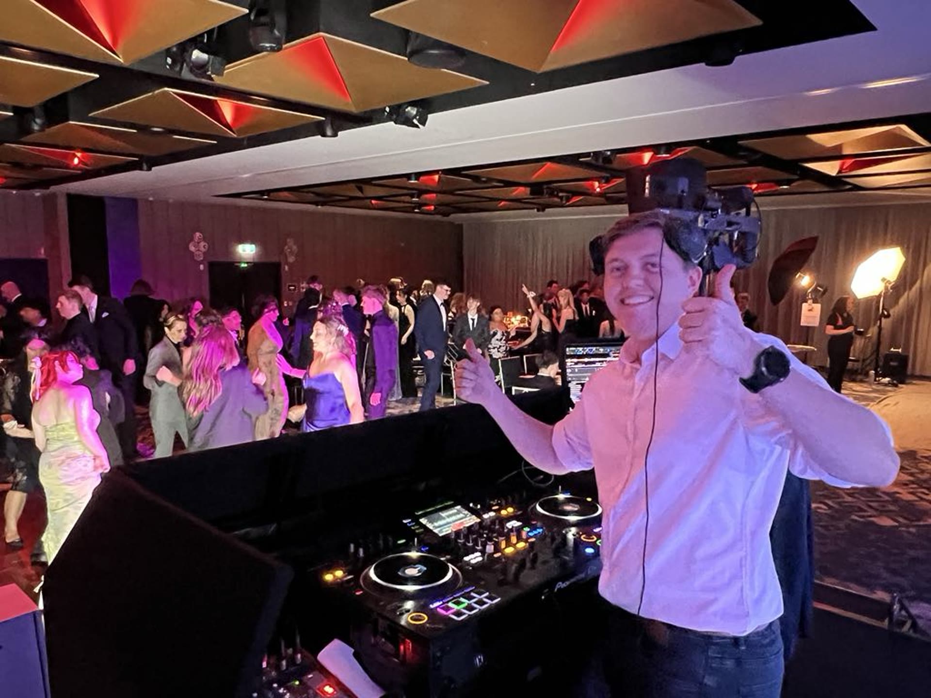 Tom DJing at Beaumonde on the Point — guests filling the dancefloor in formalwear under the venue's geometric ceiling.